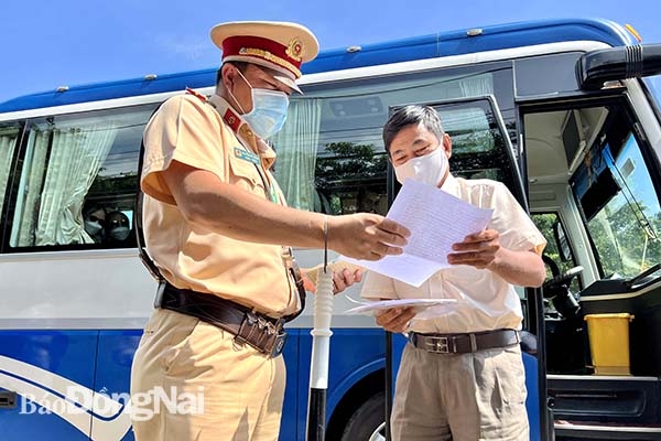 Đội Cảnh sát giao thông số 2 (Phòng Cảnh sát giao thông Công an tỉnh) kiểm tra hành chính đối với một tài xế xe khách hoạt động trên tuyến quốc lộ 20 qua địa phận H.Định Quán
