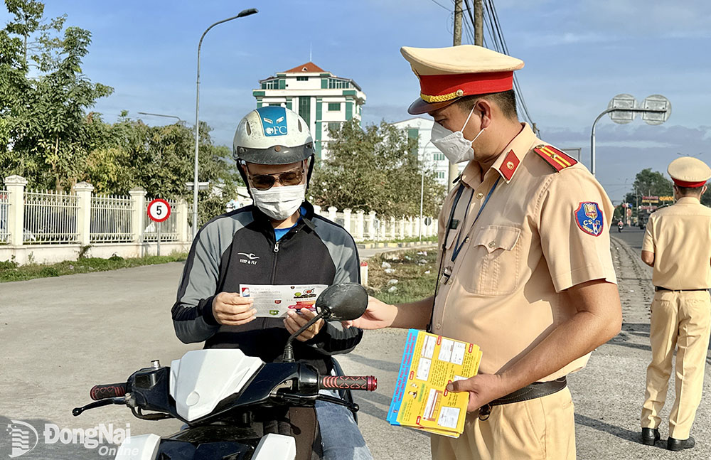 Trạm Cảnh sát giao thông Ngã ba Thái Lan (Phòng Cảnh sát giao thông Công an tỉnh) hướng dẫn, nhắc nhở người dân các quy tắc an toàn khi tham gia giao thông trên quốc lộ 51. Ảnh: Minh Thành