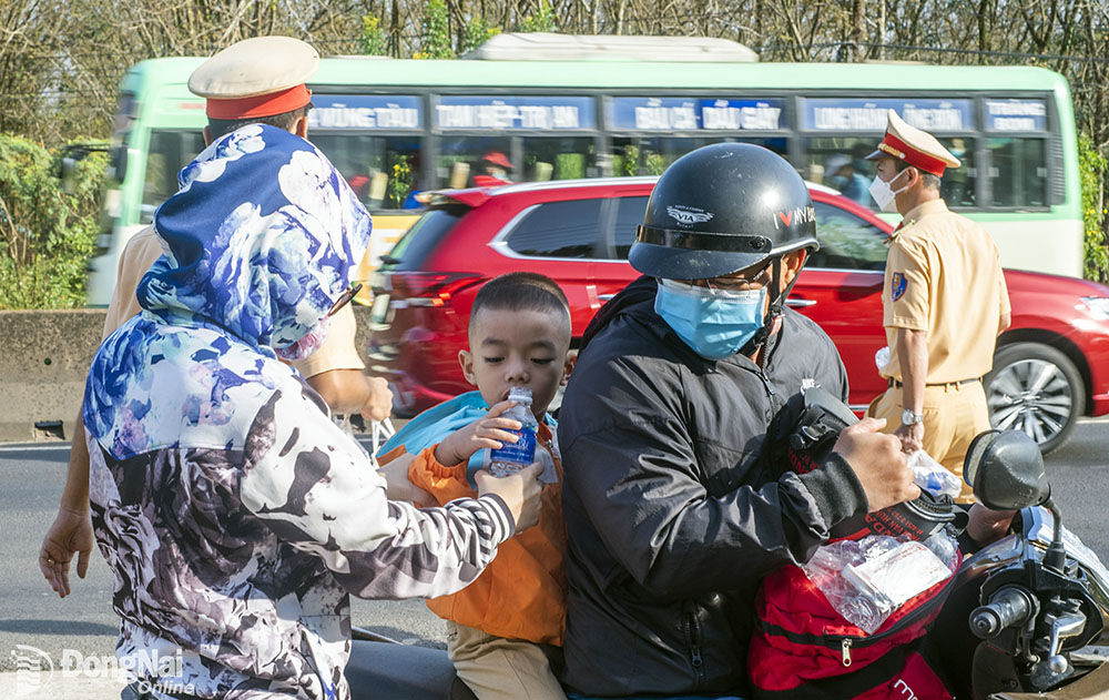 Những chai nước suối mát lạnh đã giúp cho người dân đi xe máy về quê trên quốc lộ 1 thêm sự tỉnh táo, xua đi cái nắng nóng đầu mùa khô. Ảnh: Lò Văn Hợp