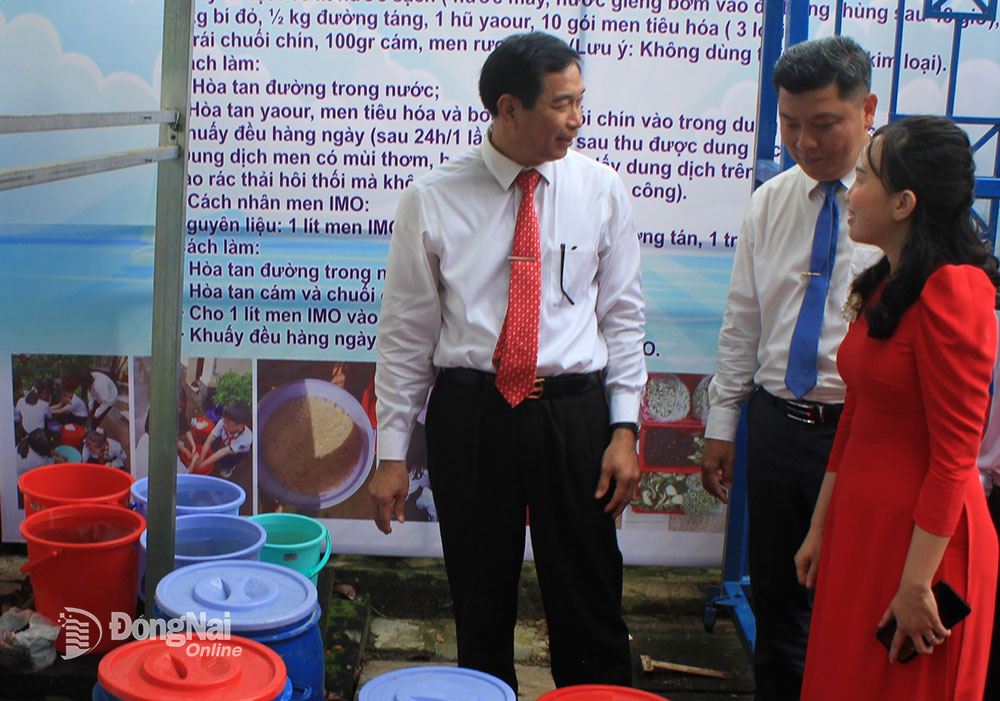 Phó chủ tịch UBND tỉnh Võ Văn Phi (bìa trái) tham quan mô hình Phân loại rác tại nguồn và sử dụng rác hữu cơ làm phân bón chăm sóc cây xanh tại Trường THCS Lê Quý Đôn (H.Vĩnh Cửu). Ảnh: B.Nguyên