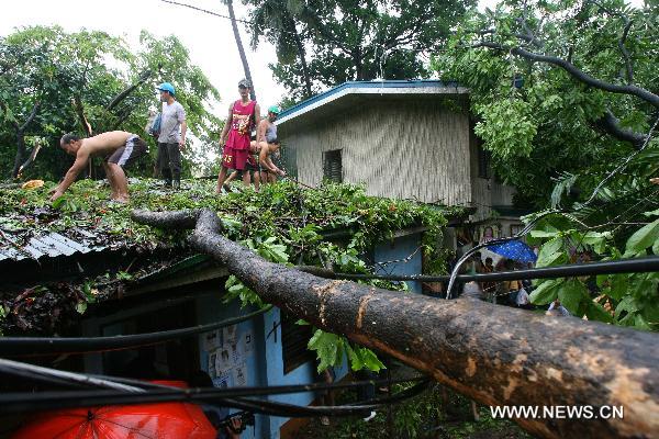 Cây bị gẫy đè lên nhà dân tại thủ đô Manila do  cơn bão nhiệt đới Meari gây ra