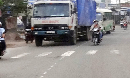 Người chạy xe máy (trong ảnh) chở trẻ em nhưng vẫn cố lấn trái vượt hai xe ô tô, tự đặt mình vào tình huống nguy hiểm. (Ảnh chụp trên đường Bùi Văn Hòa, phường Long Bình, TP. Biên Hòa).