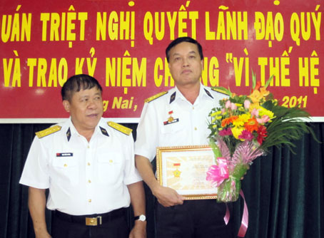 Đại tá Phạm Xuân Điệp (phải) nhận kỷ niệm chương và hoa của Trung ương Đoàn thanh niên cộng sản Hồ Chí Minh trao tặng. Ảnh: Mai Thắng