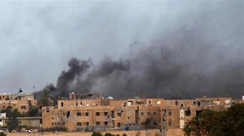 Khói bốc lên trên bầu trời Sirte, nơi đang diễn ra cuộc chiến ác liệt giữa quân chống Gaddafi và lực lượng ủng hộ ông này.   