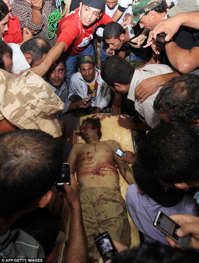 Người ta thi nhau chụp hình ảnh thi thể thảm hại của cựu Tổng thống Gaddafi.