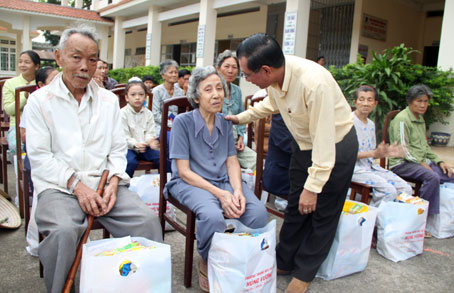 Lãnh đạo Trường THCS Hùng Vương (TP. Biên Hòa) trao quà cho bà con nghèo. Ảnh: B. Hường