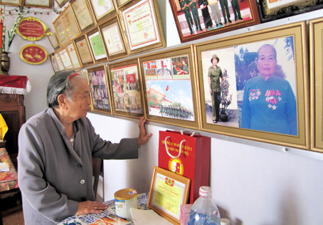 Mẹ Nguyễn Thị Thanh Vân bên những tấm di ảnh và bằng khen.
