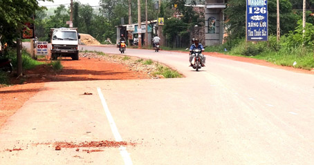 Hàng trăm mét đường tỉnh 767, đoạn gần Khu công nghiệp Sông Mây (huyện Trảng Bom), không giải tỏa được mặt bằng nên tạo ra đoạn đường hẹp, mất an toàn giao thông. Ảnh: T. Toàn