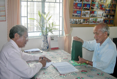 Ông Tăng Quang Thanh (phải) đang làm việc với Phó chủ tịch Hội Người cao tuổi phường Trảng Dài.