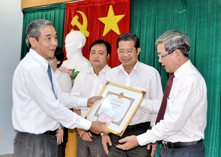 Chủ tịch HĐND tỉnh Trần Văn Tư trao bằng khen của UBND tỉnh cho Cục Thuế tỉnh. Ảnh: K.Giới