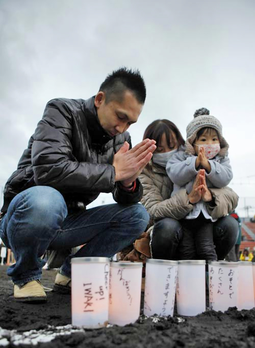 Một gia đình cầu nguyện trong một lễ tưởng niệm nạn nhân thảm họa kép tại Iwaki, tỉnh Fukushima