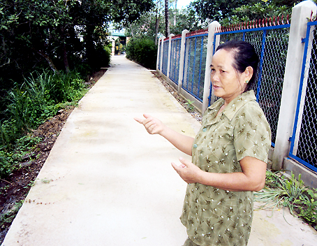 Bà Phạm Thị Thính bên con đường mới ở ấp 3, xã Gia Canh.