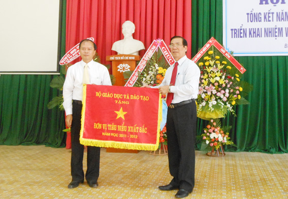 Ông Lê Minh Hoàng, Giám đốc Sở GD-ĐT (phải) trao cờ thi đua của Bộ GD-ĐT cho Phòng GD-ĐT thành phố