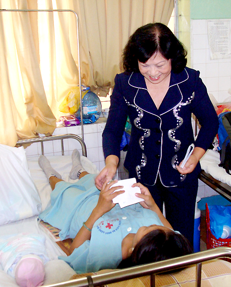 Trưởng ban Dân vận Tỉnh ủy Bùi Ngọc Thanh tặng quà cho một phụ nữ nhiễm HIV mới sinh tại Bệnh viện đa khoa Đồng Nai trong một dịp lễ.