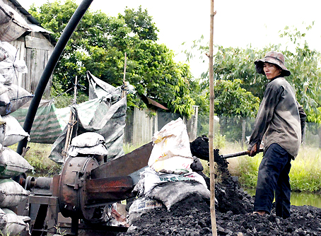Người lao động làm việc bên bãi than.