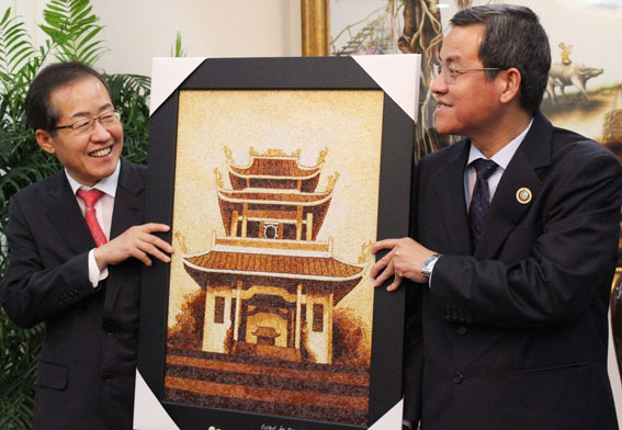 Chủ tịch UBND tỉnh Đinh Quốc Thái tặng bức tranh gạo Văn miếu Trấn Biên cho Thống Đốc tỉnh Gyeongnam.