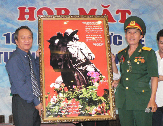 Ông Nguyễn Quốc Hoàn (bên phải) trao tặng bức tranh chụp Thi tướng đang trên mình ngựa cho ông Huỳnh Văn Nam con trai trưởng của Thi tướng Huỳnh Văn Nghệ.