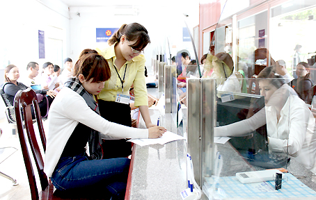 Nhân viên Bưu điện tỉnh hướng dẫn người dân đăng ký chuyển hồ sơ về nhà tại Bộ phận một cửa hiện đại của UBND TP.Biên Hòa. Ảnh: N.Thư