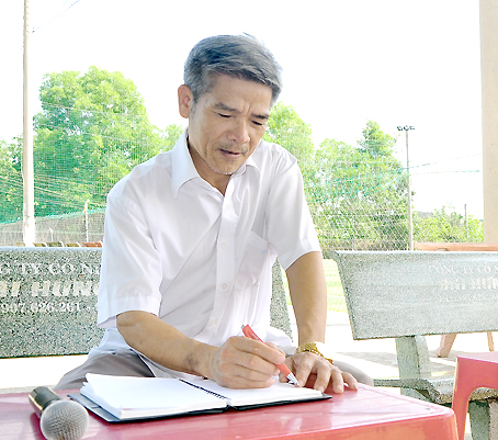 Ông Trịnh Hồng Sơn ghi chép cẩn thận tên các “cầu thủ” để không mắc sai sót khi bình luận trận đấu bóng của thanh niên trong ấp.