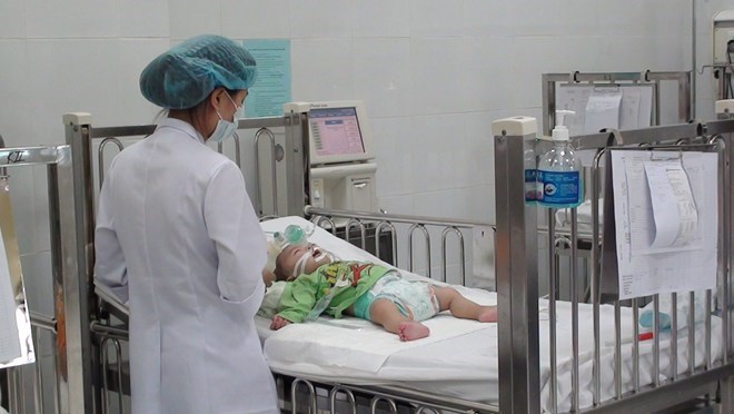 Nhân viên y tế tại Bệnh viện Nhi Trung ương chăm sóc cho trẻ mắc bệnh sởi. (Ảnh: Vietnam+)