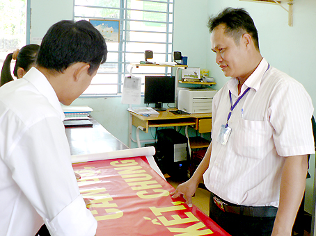 Ông Bùi Minh Hoàng (phải) trao đổi cùng đoàn viên thanh niên trong xã về kế hoạch tổ chức đêm văn nghệ chào mừng lễ kỷ niệm 30-4 và 1-5.