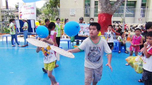 Các bé tham dự cuộc thi đưa bóng vào rổ.