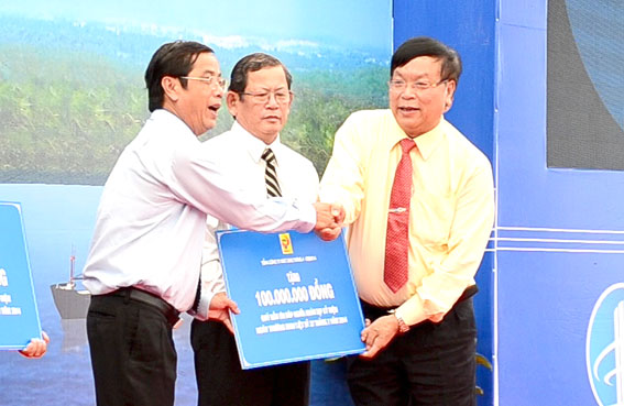Chủ tịch Ủy ban Mặt trận Tổ quốc tỉnh Vy Văn Vũ (trái) tiếp nhận 100 triệu đồng của chủ đầu tư trao tặng cho Quỹ đền ơn đáp nghĩa của tỉnh