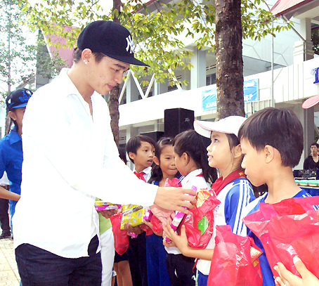 Anh Nguyễn Thanh Tùng tặng tập vở cho học sinh nghèo tại huyện Tân Phú. Ảnh: N.Sơn