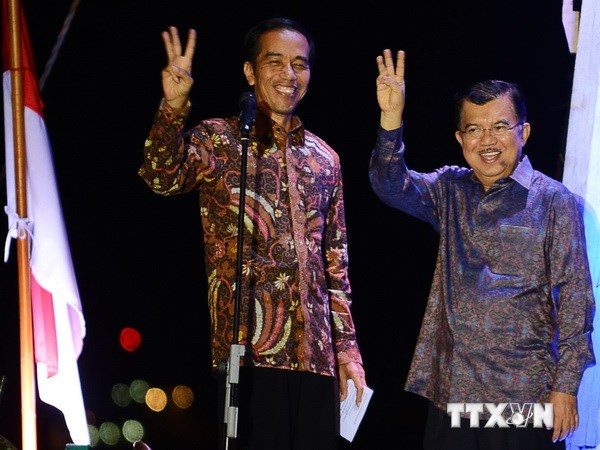 Ông Joko Widodo (trái) và liên danh tranh cử Jusuf Kalla mừng chiến thắng tại Jakarta. (Ảnh: AFP/TTXVN)