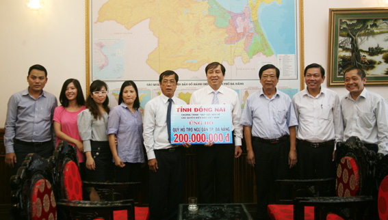 ảnh 5, đồng chí Vy Văn Vũ  và các thành viên đoàn Đồng Nai (bên trái) trao tặng tiền ủng hộ cho lãnh đạo UBND TP.Đà Nẵng để ủng họ ngư dân bám biển