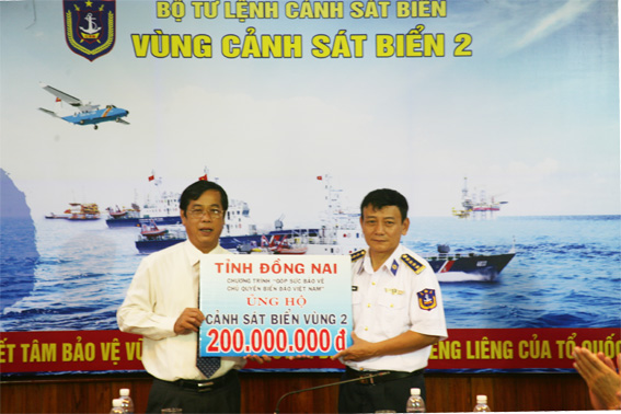 Đồng chí Vy Văn Vũ (bên trái) trao tặng tiền ủng hộ cho lãnh đạo Vùng cảnh sát biển 2