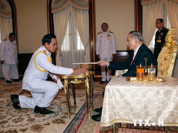 Lãnh đạo chính quyền quân sự Thái Lan, Tư lệnh Lục quân Prayuth Chan-ocha (trái) nhận bản Hiến pháp lâm thời từ Nhà Vua Bhumibol Adulyadej. (Ảnh: AFP/TTXVN)