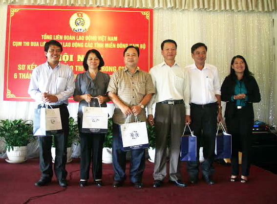 đại diện Liên đoàn Lao động tỉnh Đồng Nai (bên phải) tặng quà lưu niệm cho lãnh đạo Liên đoàn Lao động các tỉnh trong cụm thi đua.