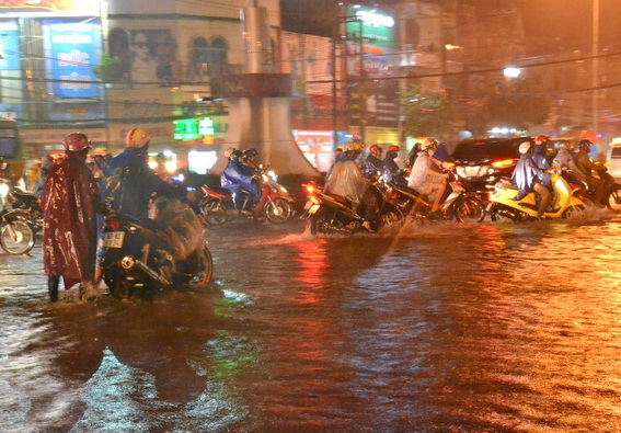 Khu vực ngã tư Tân Phong cũng bị ngập sâu trong nước khiến xe máy qua lại nơi đây nhiều xe bị chết máy (K.Giới)