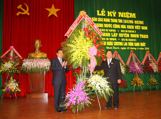 Đồng chí Trần Đình Thành tặng lẵng hoa của Tỉnh ủy – HĐND – UBND và  Ủy ban MTTQ tỉnh cho Đảng bộ và nhân dân huyện Nhơn Trạch