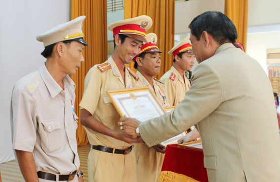 Chủ tịch UBND huyện Lê Văn Ý trao giấy khen cho các cá nhân dũng cảm bắt cướp ở xã Bình Sơn.  