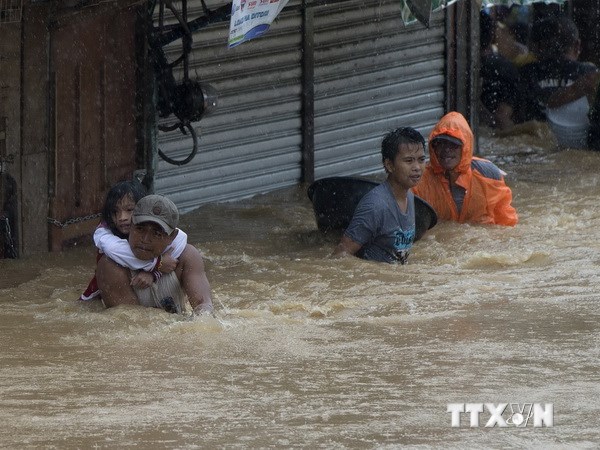 Người dân sơ tán khỏi khu vực ngập lụt do bão Fung-Wong ở Marikina, ngoại ô Manila ngày 19/9. AFP-TTXVN