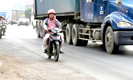 Nghe điện thoại bất kể xe ô tô chạy kề bên gây nguy hiểm. Ảnh: T.TOÀN