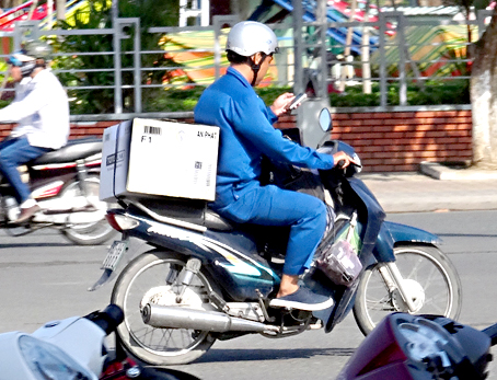 Vừa lái xe vừa chăm chú nhìn màn hình điện thoại trên quốc lộ 1.