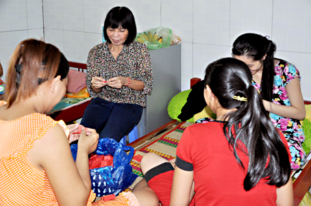 Bà Nguyễn Thị Căn (ngồi giữa), quản lý nhà tạm lánh Mai Tiến, đến động viên các bà mẹ trẻ.