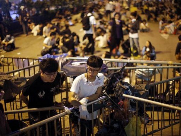 Người biểu tình đứng canh một rào chắn ở Mong Kok sau các cuộc xung đột với cảnh sát rạng sáng 18/10 (Nguồn: Reuters)