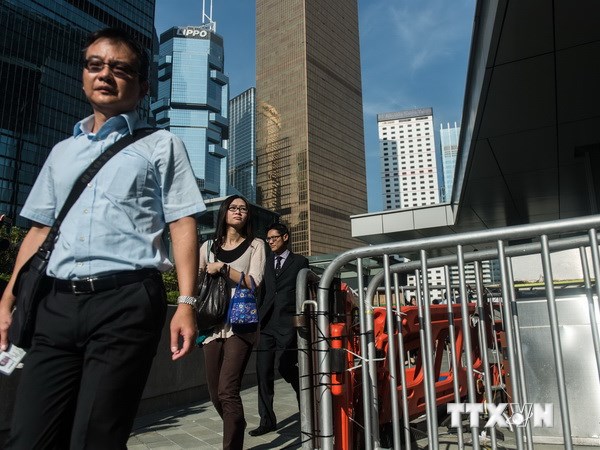 Người đi làm bằng vé tháng Hong Kong trở lại làm việc tại các cơ quan công quyền ngày 6/10. (Nguồn: AFP/TTXVN)