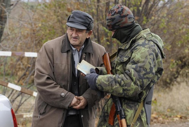 Binh sỹ Ukraine kiểm tra hộ chiếu một người dân ở Bugas, Donetsk, ngày 24/10. (Nguồn: AFP)