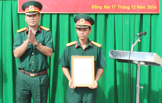 Đại diện Lữ đoàn Tăng thiết giáp 22 trao quyết định bàn giao nhà cho gia đình Trung úy Hồ Bá Thìn (phải).