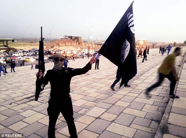 Một tay súng IS cầm lá cờ đen ở thành phố Mosul. (Nguồn: Reuters)