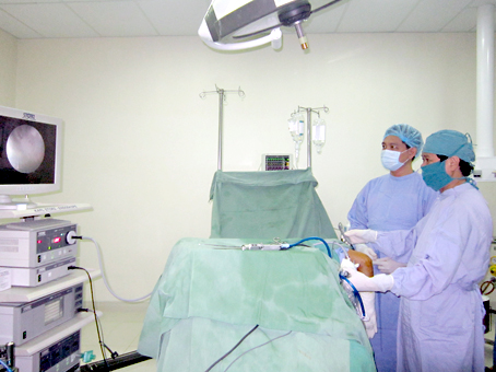 Bác sĩ Nguyễn Tường Quang (bìa phải) thực hiện ca mổ nội soi khớp khuỷu cho bệnh nhân Lê Đình Nguyên. Ảnh: N.THƯ