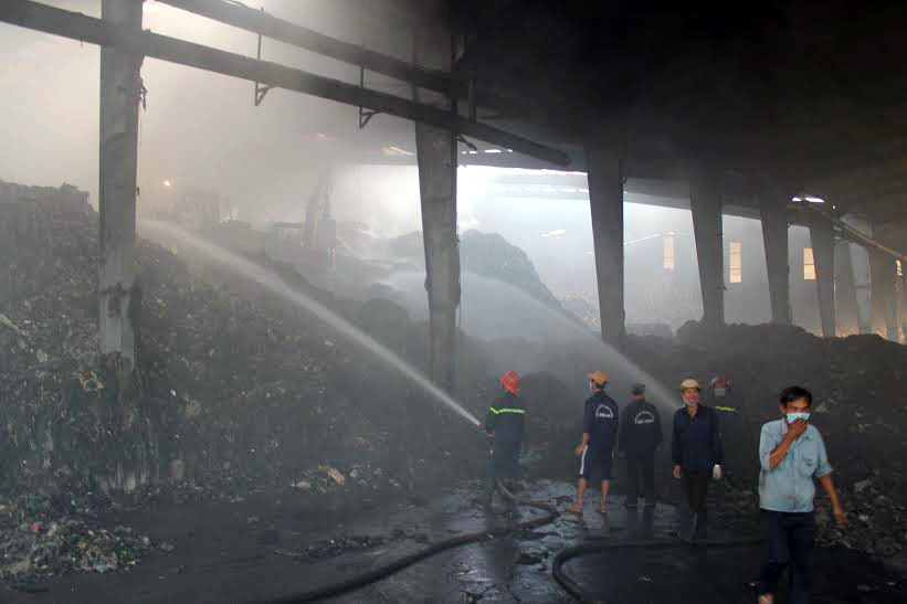 Lực lượng chữa cháy đang nổ lực dập tắt lửa dưới khối rác khổng lồ.