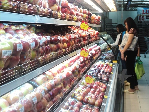 Người tiêu dùng mua táo tại siêu thị. (Ảnh: Vietnam+)