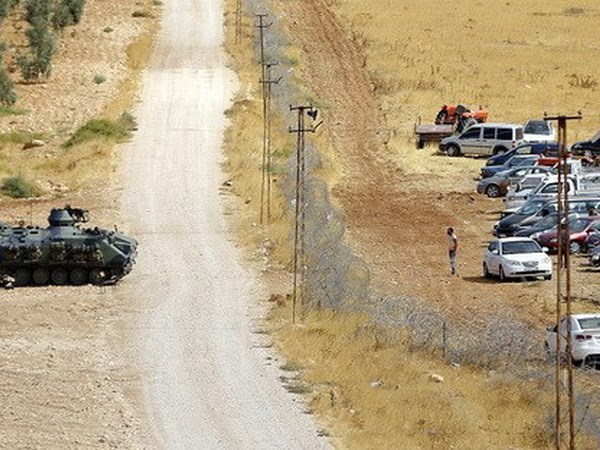 Một chiếc xe tăng Thổ Nhĩ Kỳ và hàng chục xe ôtô của dân Syria ở khu vực biên giới. (Nguồn: EPA)