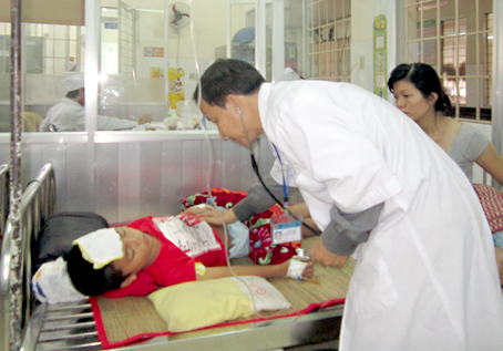 Bác sĩ Hà Văn Thiệu (Bệnh viện nhi đồng Đồng Nai) khám bệnh cho bé Huỳnh Anh Dũng.  Ảnh: A.AN